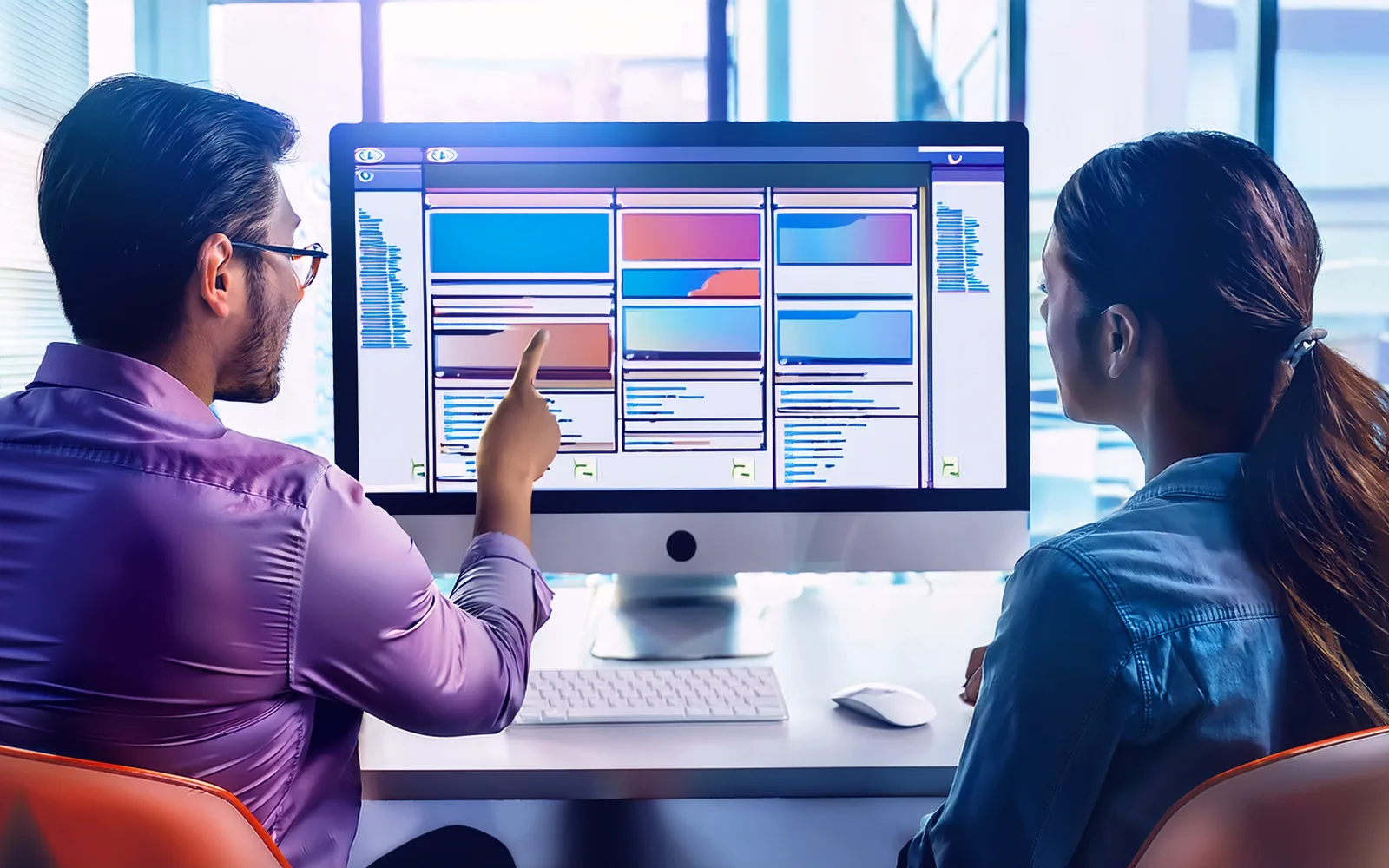Dues persones revisen el disseny d'una pàgina web en un monitor